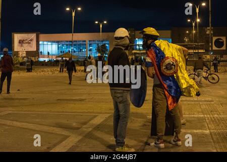 Bogota, Kolumbien. Juni 2021. Die Demonstranten der Front benutzen kolumbianische Flaggen, als in der Nacht des 17. Juni 2021 in Bogota, Kolumbien, die Zusammenstöße zwischen Demonstranten und der kolumbianischen Bereitschaftspolizei (ESMAD) eskalierten, während regierungsfeindliche Proteste gegen die Polizeibrutalität und die Regierung von Präsident Ivan Duque stattfanden. Kredit: Long Visual Press/Alamy Live Nachrichten Stockfoto