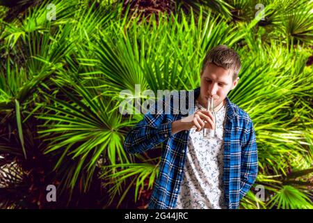 Hand hält eine Glasflasche an einem Sommertag Stockfoto