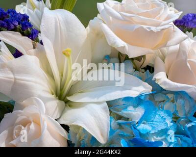 Blumenarrangement aus weißen Lilien und Rosen Stockfoto