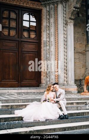 Eingang zur Basilika Santa Maria Maggiore in Rom. Brautpaar sitzen auf den Stufen und umarmen sich. Braut hält eine Bouque Stockfoto