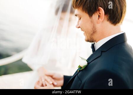 Der Bräutigam legt den Ring während der Hochzeit auf den Finger der Braut Die Hochzeitszeremonie Stockfoto