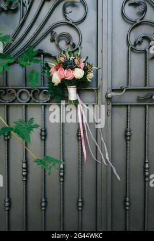 Brautstrauß aus weißen und rosafarbenen Rosen, Buchsbaum-Ästen, Aronia, veronica-Blumen, rosa und weißen Bändern auf der schönen Forg Stockfoto