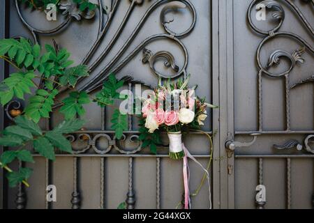 Brautstrauß aus weißen und rosafarbenen Rosen, Buchsbaum-Ästen, Aronia, veronica-Blumen, rosa und weißen Bändern auf der schönen Forg Stockfoto