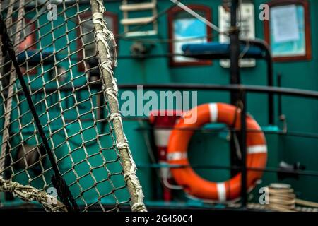 Netz und Rettungsring auf einem Fischerboot in Groningen, Niederlande Stockfoto