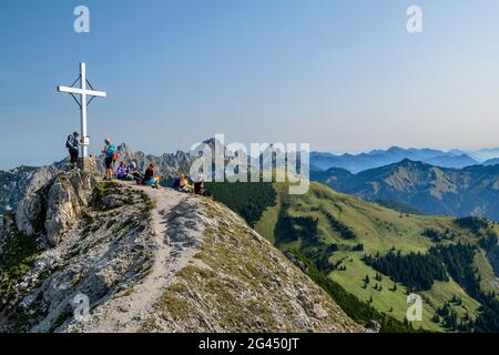 Mehrere Personen sitzen auf dem Gipfel der Litnisschrofen, Gimpel, Köllenspitze und Gehrenspitze im Hintergrund, Litnisschrofen, Tannheimer Berge, Tirol, Stockfoto