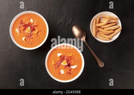 Salmorejo, spanische kalte Tomatensuppe, Topshot auf schwarzem Hintergrund Stockfoto