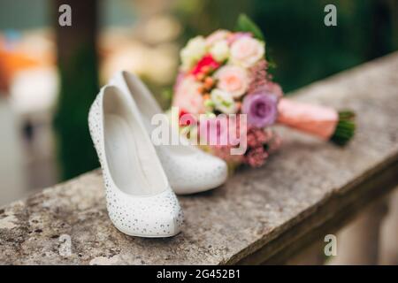 Die Schuhe der Braut liegen auf dem grünen Gras Stockfoto