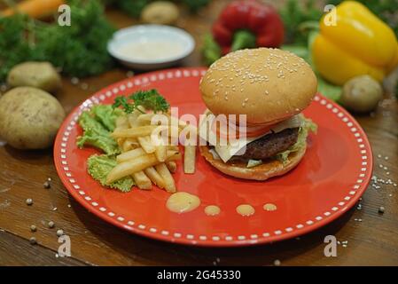 Leckere Burger mit Rinderschnitzel und Pommes auf Holztisch Stockfoto