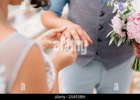 Die Braut legt dabei den Ring auf den Finger des Bräutigams Die Hochzeitszeremonie Stockfoto