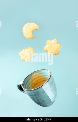 Dänische Butterkeks und eine Tasse Tee auf blauem Hintergrund Stockfoto