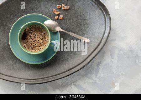 Eine Nahaufnahme einer Tasse schwarzen Kaffees, von oben auf ein Tablett mit karamellisiertem Zucker geschossen Stockfoto