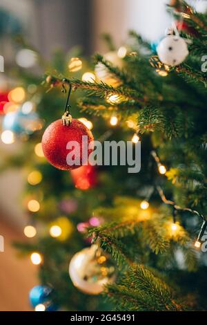 Ein kleiner Weihnachtsbaum in einem Topf, geschmückt mit Kugeln, Girlanden Stockfoto