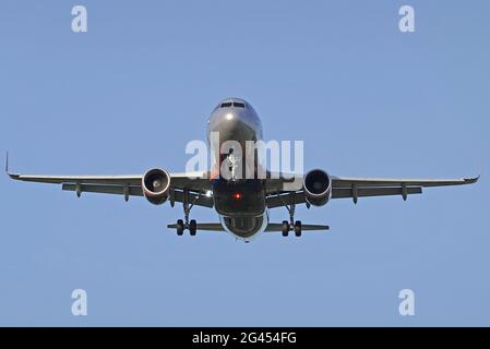 Das Flugzeug fliegt vor dem Hintergrund des blauen Himmels Stockfoto