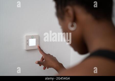 Junge schwarze Frau, die zuhause Hausautomation nutzt Stockfoto