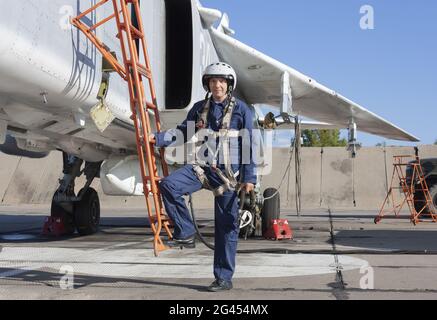 Militärpilot im Helm steht in der Nähe von Jet-Flugzeug Stockfoto