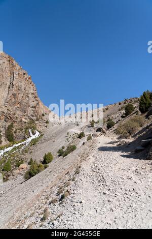 Die schöne Bergwanderstraße mit klarem blauen Himmel und felsigen Hügeln in den Fann Bergen in Tadschikistan Stockfoto