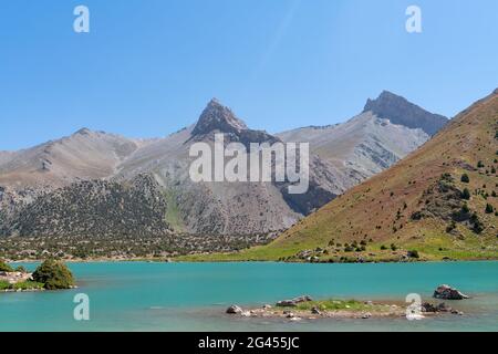 Der Pamir-Bergblick und ruhiger Campingplatz am Kulikalon-See im Fann-Gebirge in Tadschikistan. Bunte Reflexion in pur aufmuntern Stockfoto