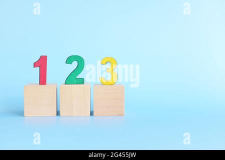 Bunte 123 Zahlen auf Holzblöcken auf blauem Hintergrund mit Kopierplatz. Beginn des Kindes oder Kind lernen Zählkonzept. Stockfoto