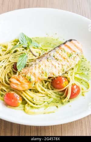 Spaghetti Pesto Lachs in weißem Teller auf Holztisch Stockfoto