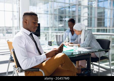 Geschäftsmann mit digital-Tablette am Schreibtisch im Büro Stockfoto