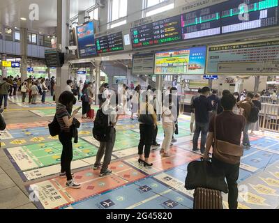 Tokio, Japan. Mai 2021. Reisende stehen auf zahlreichen Markierungen an der Shinagawa Station. Die Japaner werden aufgefordert, sich bei jeder Runde richtig zu verhalten. Eine fast unüberschaubare Flut von Verhaltensregeln begleitet ihren Alltag. Einige von ihnen wirken geradezu bizarr. (To dpa: 'Zwischen Vorschriften und Streben nach Harmonie - Japans Obsession mit Regeln') Quelle: Lars Nicolaysen/dpa/Alamy Live News Stockfoto