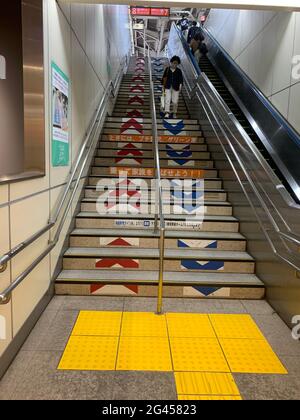 Tokio, Japan. Mai 2021. Markierungen für die korrekte Verwendung der Bahnhofsstufen in einem Bahnhof. Die Japaner werden gebeten, sich bei jeder Wende korrekt zu verhalten. Eine fast unüberschaubare Flut von Verhaltensregeln begleitet ihren Alltag. Einige von ihnen wirken geradezu bizarr. (To dpa: 'Zwischen Vorschriften und Streben nach Harmonie - Japans Obsession mit Regeln') Quelle: Lars Nicolaysen/dpa/Alamy Live News Stockfoto