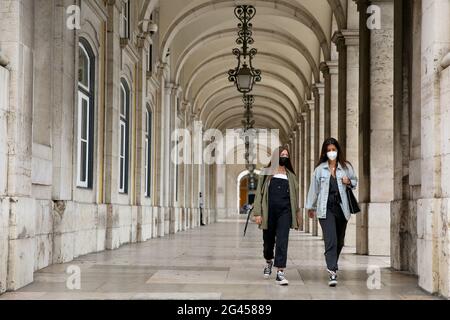 Lissabon, Portugal. Juni 2021. Menschen mit Gesichtsmasken gehen in die Innenstadt von Lissabon, Portugal, 18. Juni 2021. Die portugiesische Regierung kündigte am Donnerstag an, dass das gesamte Stadtgebiet von Lissabon (AML) am Wochenende von 3 Uhr am Freitag bis 6 Uhr am kommenden Montag isoliert sein wird, um die Erhöhung der COVID-19-Fälle in der Hauptstadt des Landes einzudämmen. Quelle: Pedro Fiuza/Xinhua/Alamy Live News Stockfoto