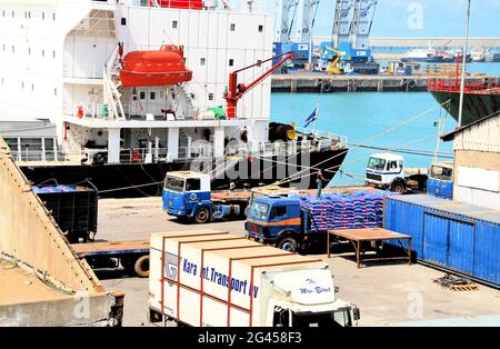 Verladung von importierten Waren aus dem Schiff auf Lastwagen im Hafen von Lomé, Togo, Westafrika. Stockfoto