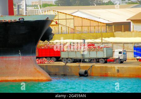 Im Hafen von Cotonou, Benin, Westafrika, werden auf dem Pier Schiffe, die importiert werden, auf Lastwagen entladen. Stockfoto