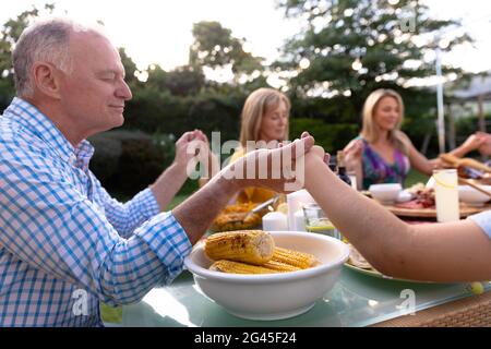 Kaukasische Familie sagen Gnade zusammen vor dem Essen Stockfoto