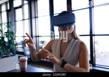 Asiatische Frau nutzt virtuelle Realität bei der Arbeit Stockfoto