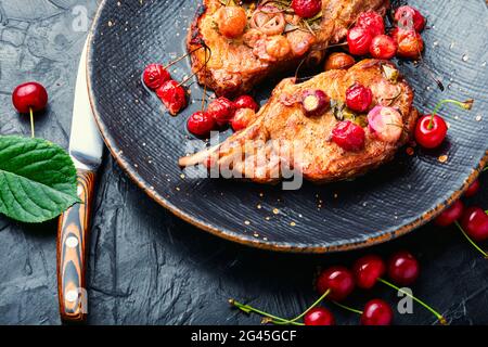 Schweinefleisch auf dem Knochen Braten in Beerenmarinat.gegrillte Schweinesteaks in Kirschweinsauce Stockfoto