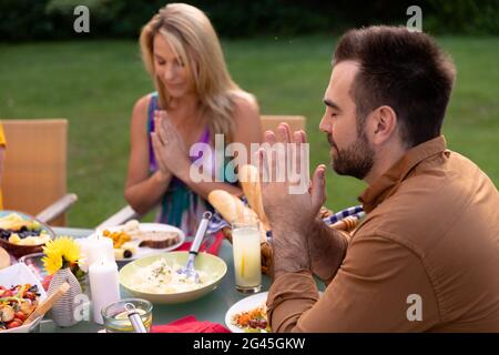 Kaukasische Familie sagen Gnade zusammen vor dem Essen Stockfoto
