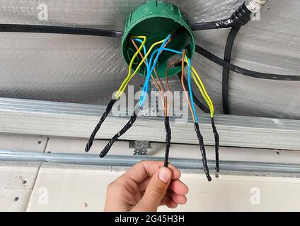 Elektrische Verdrahtung des Anschlusskastens, Installation, Verdrehen des Kastens durch einen Elektriker. Selektiver Fokus. Stockfoto