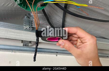 Elektrische Verdrahtung des Anschlusskastens, Installation, Verdrehen des Kastens durch einen Elektriker. Selektiver Fokus. Stockfoto