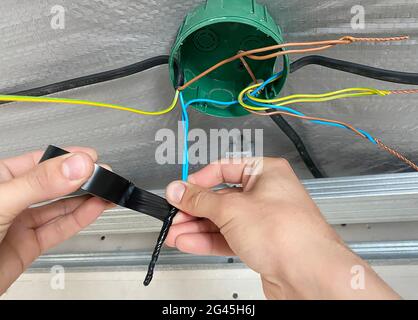 Elektrische Verdrahtung des Anschlusskastens, Installation, Verdrehen des Kastens durch einen Elektriker. Selektiver Fokus. Stockfoto