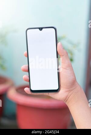 Mann hält Smartphone mit leerem Bildschirm auf weißem Hintergrund, Nahaufnahme der Hand. Platz für Text. Stockfoto