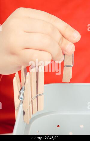 Vorschulkinder spielen mit Holzclip. Entwicklung von motorischen Fähigkeiten, Koordination und Kreativität der Kinder Stockfoto