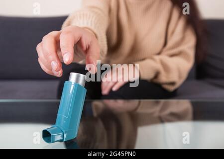 Junge Frau, die während eines starken Asthmaanfalls nach einem Asthma-Inhalator sucht, atmet nicht, Gesundheitskonzept Stockfoto