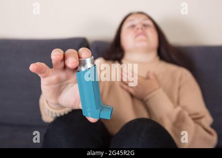 Junge Frau, die während eines starken Asthmaanfalls nach einem Asthma-Inhalator sucht, atmet nicht, Gesundheitskonzept Stockfoto