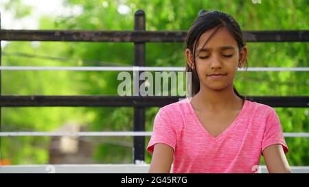 Jaipur, Rajasthan, Indien - Juni 2021: Yoga-Konzept. Asiatische kleine niedliche Mädchen üben Yoga-Übung mit Lächeln und Glück. Internationaler Yoga-Tag Stockfoto