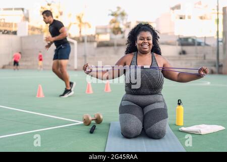 Kurvige Afro-Frau macht Workout-Übungen - Young African Weibliche mit Spaß Training im Freien - Sportliche Menschen Lifestyle-Konzept Stockfoto