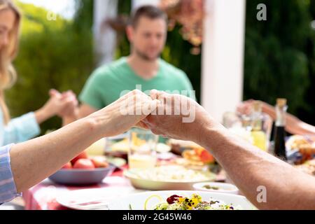 Kaukasische Familie drei Generation während eines Mittagessens im Garten beten Stockfoto