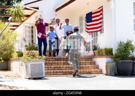 Afroamerikanischer Soldat in Uniform und seine Familie steht bei ihrem Haus Stockfoto