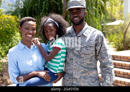 Afroamerikanischer Soldat in Uniform und seine Familie steht bei ihrem Haus Stockfoto