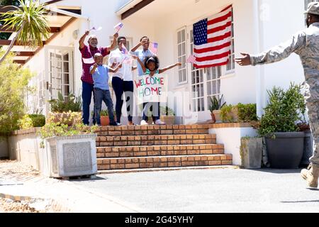 Afroamerikanischer Soldat in Uniform und seine Familie steht bei ihrem Haus Stockfoto