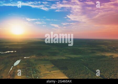 Ländliche Landschaft mit schönen bunten Abendhimmel bei Sonnenuntergang. Luftaufnahme Stockfoto
