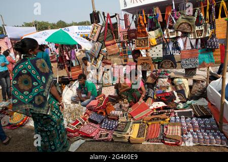 Eine Frau, die traditionelle handgemachte Taschen aus Kleidung und Leder in der Poush Mela verkauft, einer Messe von etwa 127 Jahren in Shantiniketan, Westbengalen, Indien Stockfoto