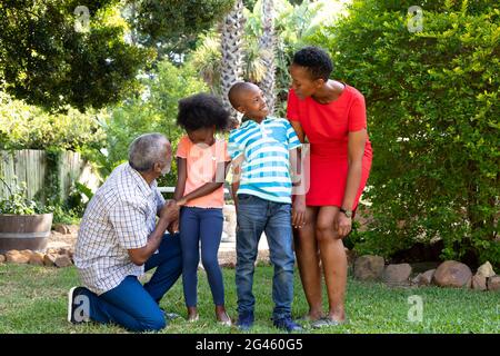 Ältere afroamerikanische Paar Zeit in ihrem Enkel und Enkelin im Garten Stockfoto