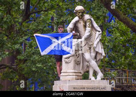 London, Großbritannien. Juni 2021. Ein schottischer Unterstützer klettert auf die Statue von William Shakespeare auf dem Leicester Square. Tausende schottischer Anhänger versammelten sich im Zentrum von London vor dem Spiel der England-Schottland UEFA Euro 2020 im Wembley Stadium. Stockfoto